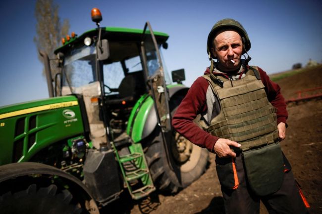 战火中的乌克兰农民：穿防弹衣、带头盔耕作