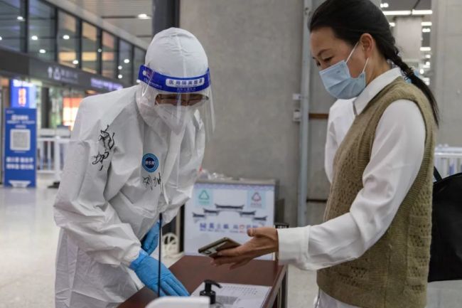 在合肥南站出站口，志愿者协助工作人员核验旅客“两码”。李晓东 摄（图源：安徽图片网）