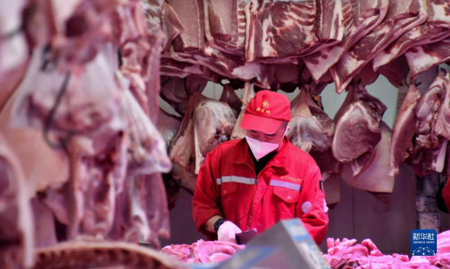 5月20日，新发地市场的肉类批发商户在分割猪肉。