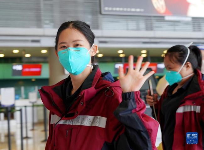 5月23日，在上海虹桥国际机场，一名海南援沪医疗队队员向送行人员挥手道别。