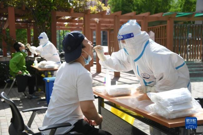 在北京市海淀区中关村街道的一处临时核酸检测采样点，医护人员为市民进行核酸采样。新华社记者任超摄。
