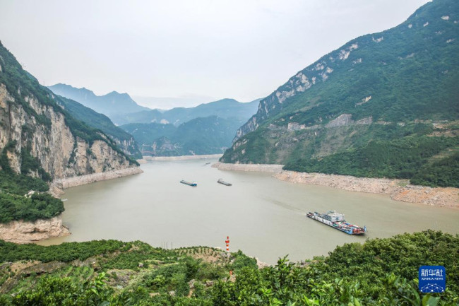 6月9日，船舶行驶在三峡大坝上游湖北省宜昌市秭归县西陵峡水域，三峡水库水位下降后的消落带清晰可见。