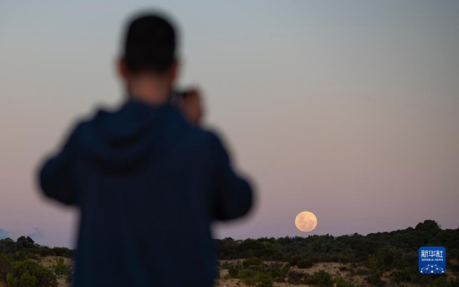 6月14日，一名男子在位于澳大利亚西澳大利亚州的尖峰石阵拍摄“超级月亮”。