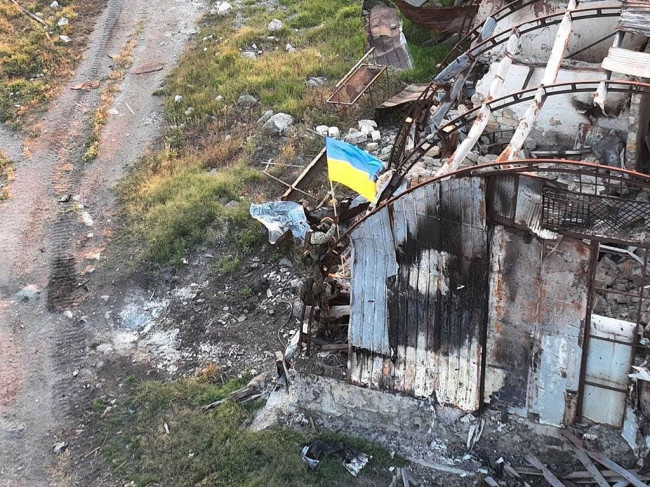 当地时间2022年7月7日，蛇岛，一名乌克兰士兵在Bile村悬挂乌克兰国旗。