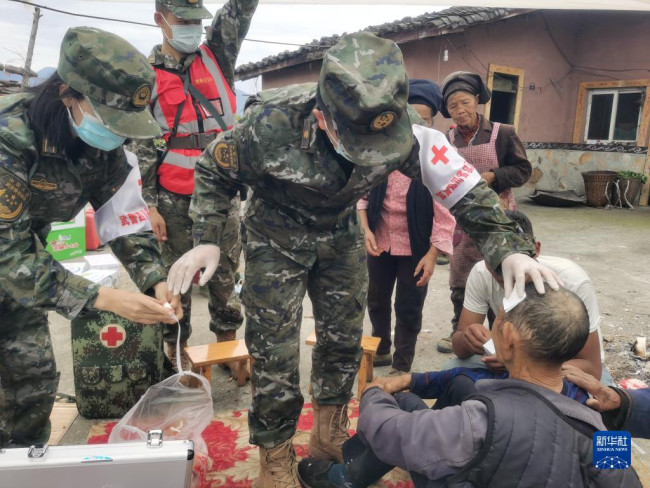 9月6日，武警四川总队医院医疗队在泸定县磨西镇救治伤员。新华社发（李华时 摄）