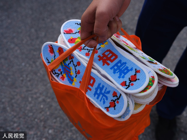 居民提着鞋垫要送给即将离开的救灾官兵。
