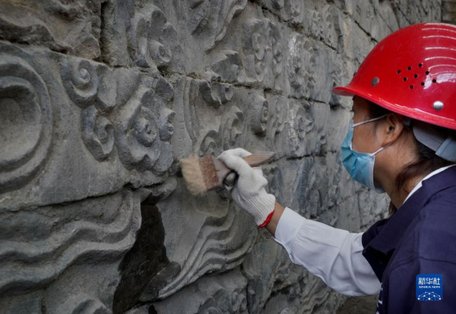 工作人员在清理巨幅石雕祥瑞壁画（9月21日摄）。新华社记者 李安 摄