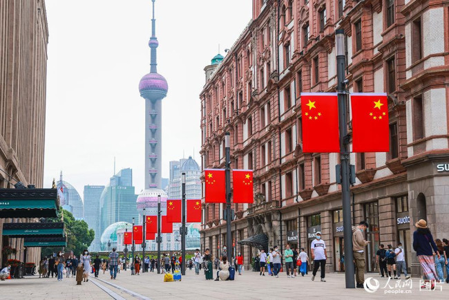 9月30日，上海南京路步行街悬挂上了五星红旗喜迎国庆，节日气氛浓烈，吸引了不少市民、游客。人民网记者 王初摄