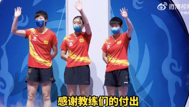 孙颖莎把金牌挂在教练脖子上