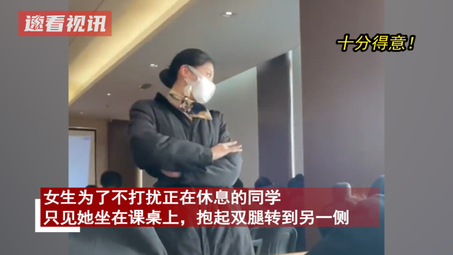 女生为不打扰同学休息坐桌上抱腿跨过，还摆了一个得意姿势