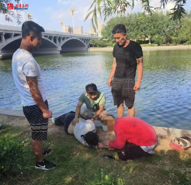 女子落水4男子合力救助 拉上岸后又现场进行急救，最终使她脱险