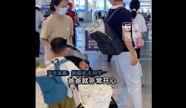 父子俩在车站接妈妈妹妹