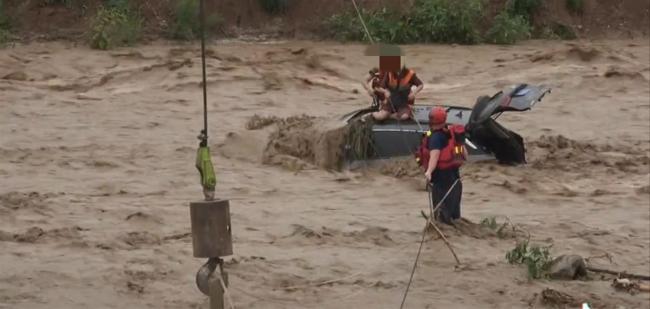 汽车被冲至河道两人被困 男子要求先救女朋友 整个营救行动历时3个多小时
