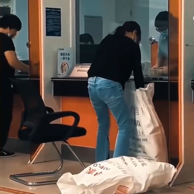 女子拿麻袋装钱吓懵众人