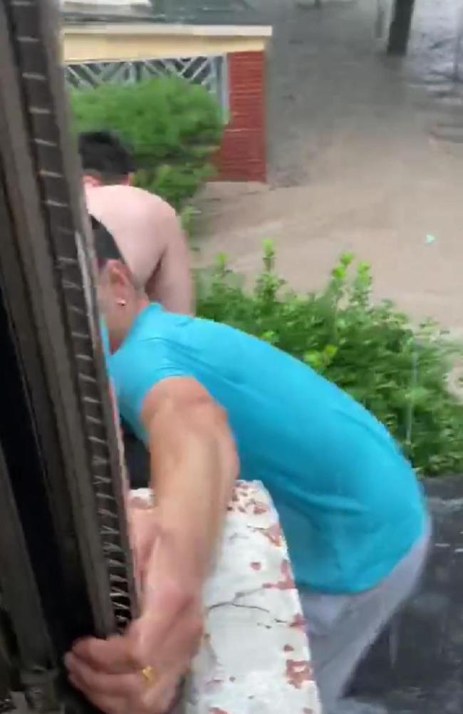 北京大雨女生被困洪水抱大树 两邻居抛绳索合力将其救回
