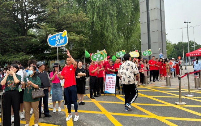 高考首日北京考场外的暖心瞬间 老师红衣助威击掌传递力量