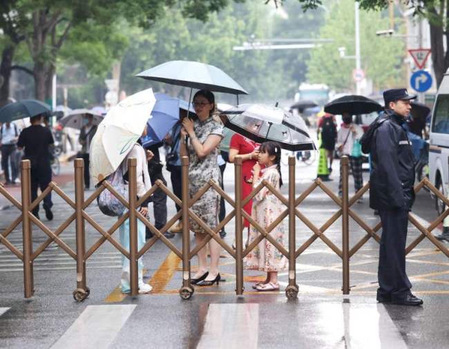 高考首日北京交警雨中值守，加强考点周边秩序疏导