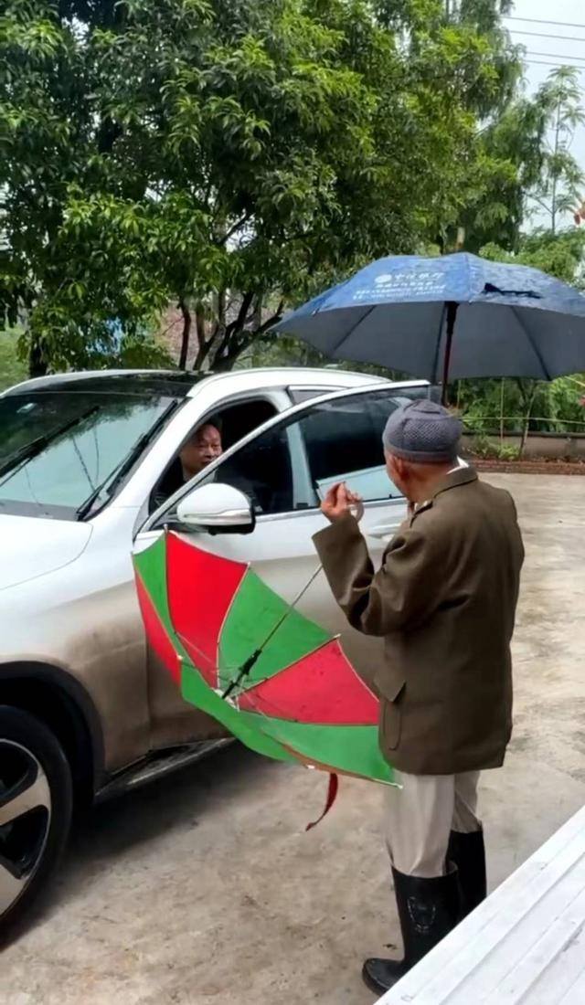101岁爷爷给55岁孙子雨中送伞
