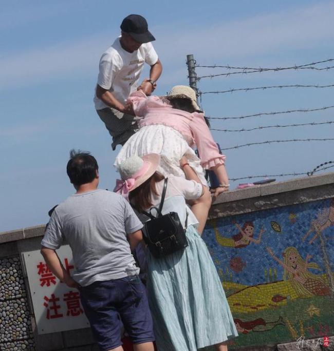 上海奉贤海湾游客翻越铁丝网下海 无视安全警示翻墙游玩