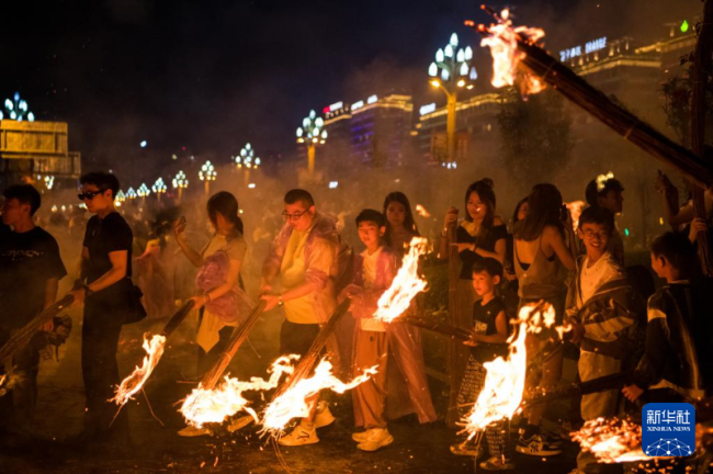 彝族火把节点燃中国凉都盛夏 民俗狂欢引游客热潮