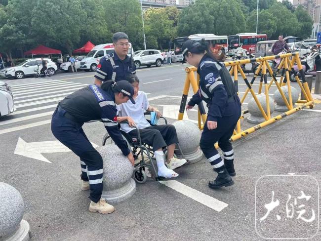 考生腿部骨折坐轮椅参加高考 志愿者暖心护考