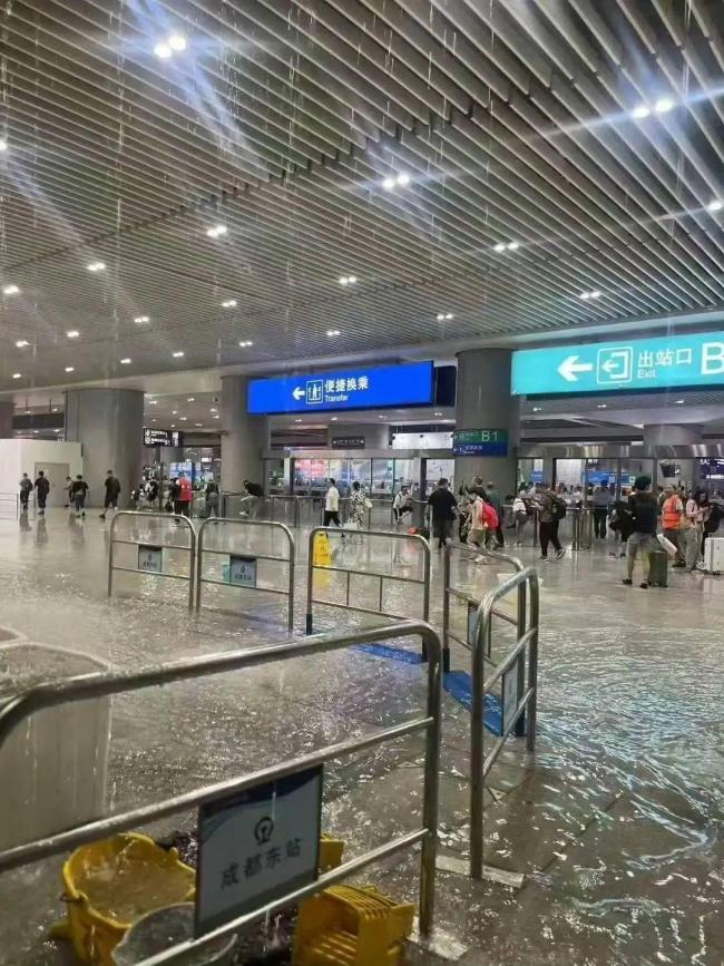 成都东站旅客踩沙包出站 强降雨致积水严重