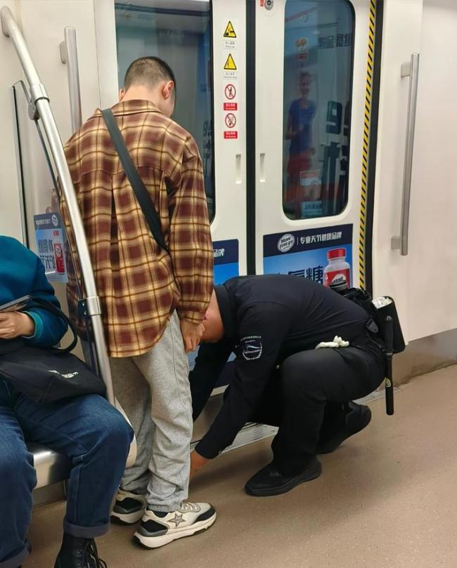 成都地铁保安帮行动不便乘客系鞋带