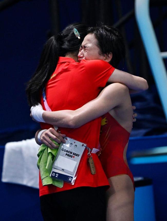 全红婵训练场边独自缠肌贴绑带