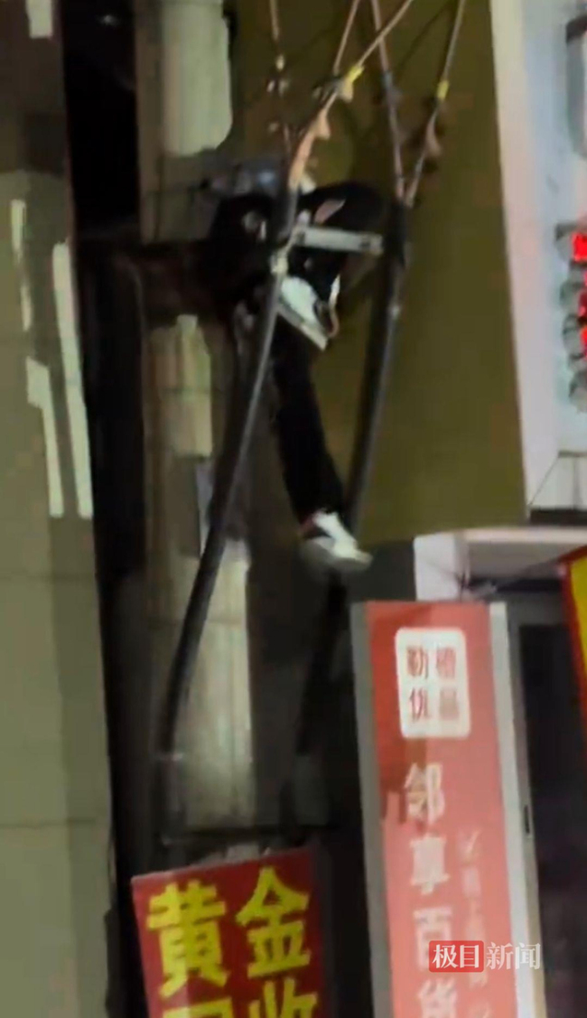 男子凌晨吊挂万伏高压电杆支架