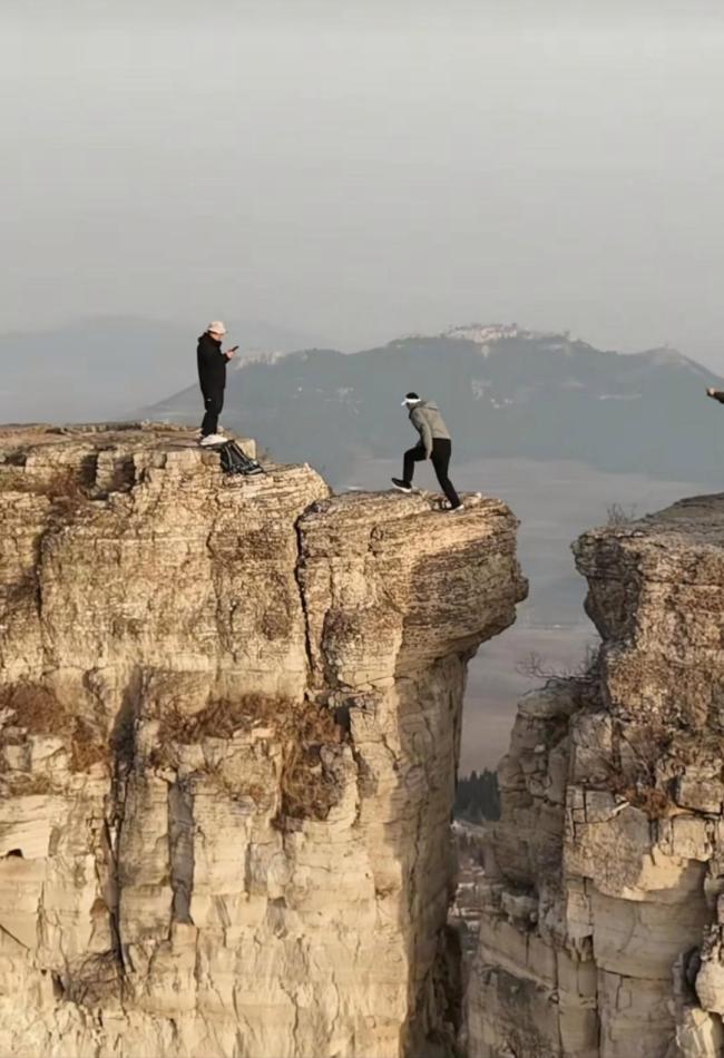 危險動作！多名男子在近3米高崖間跳躍