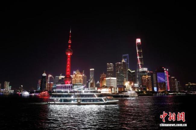 游客欣赏上海黄浦江两岸夜景 流光溢彩映外滩
