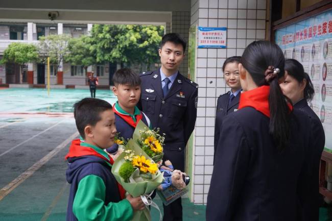 小学生在入队仪式上收到民警锦旗 拾金不昧获表彰