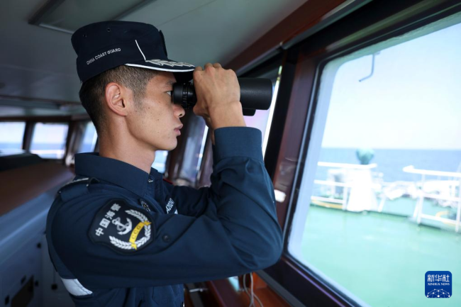 5月5日，海警川山舰执法员廖静龙在巡航警戒演练中瞭望海面情况。新华社记者 陈斌 摄