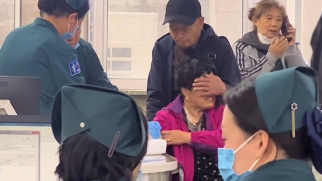 阿姨害怕扎针大叔帮捂住眼睛