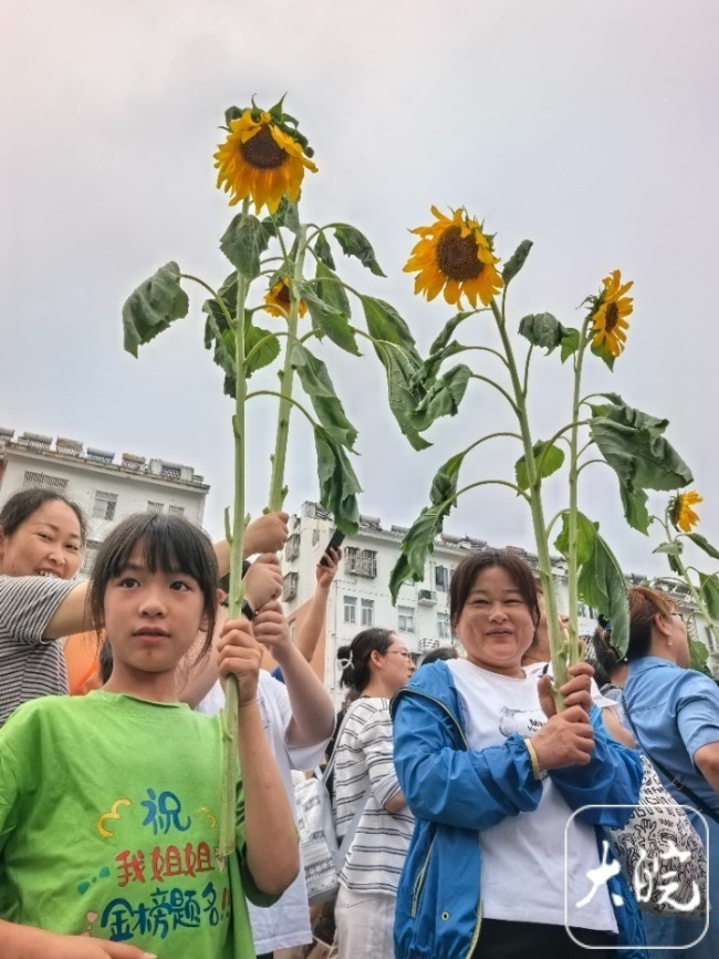 妹妹高举向日葵迎接姐姐出考点