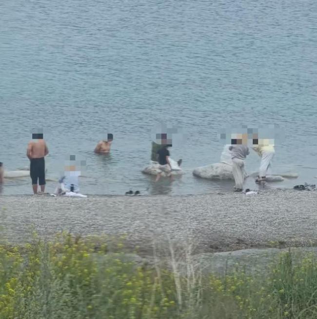 多名游客在赛里木湖游泳