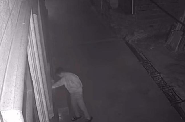 男孩深夜在别人家门口点火
