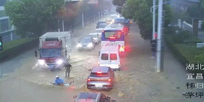 货车司机回应路口冒雨救人