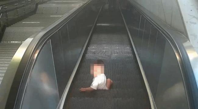 保洁员抱住误入地铁扶梯幼童