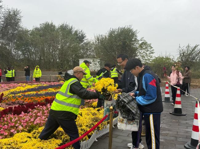 北京上百位市民雨中排队 接国庆鲜 花香传递节日温情