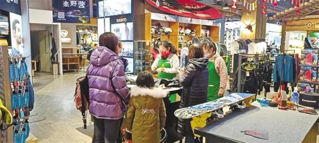 2月8日，滑雪爱好者在西安绿蚂蚁野外用品店挑选冰雪运动装备