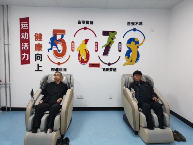 两位老人正在原中医院改建的失能半失能养老中心休闲按摩