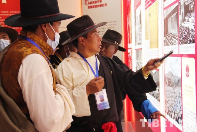 图为西藏基层干部在阅览展板前，观看有关民族区域自治制度的相关内容。 摄影：王茜