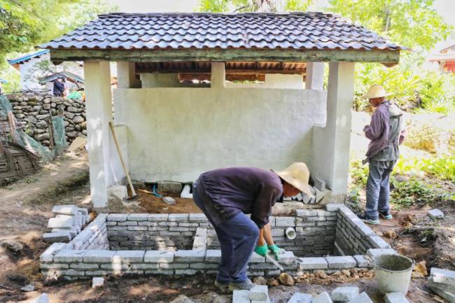 工人正在金江镇吾竹村进行农村三格式户厕建设