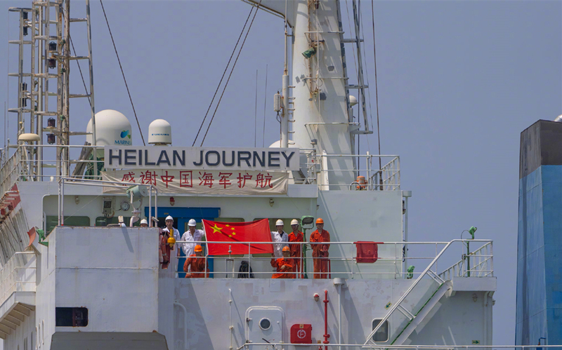 中国船员在亚丁湾举国旗感谢人民海军